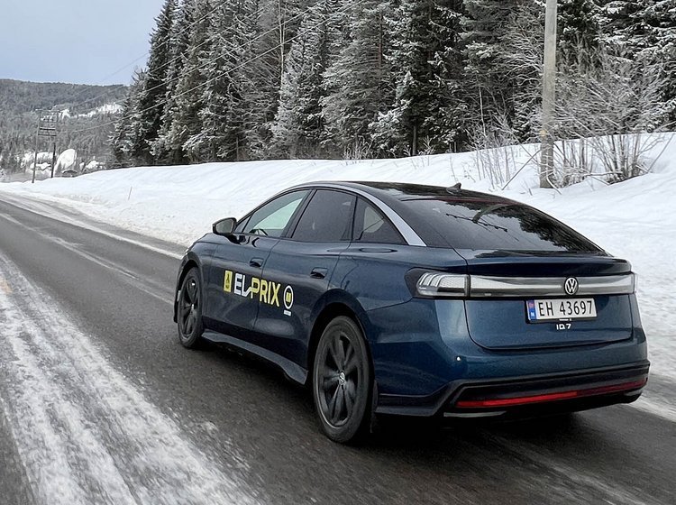 Blå VW ID.7 kører på en norsk landevej med sne i baggrunden. 