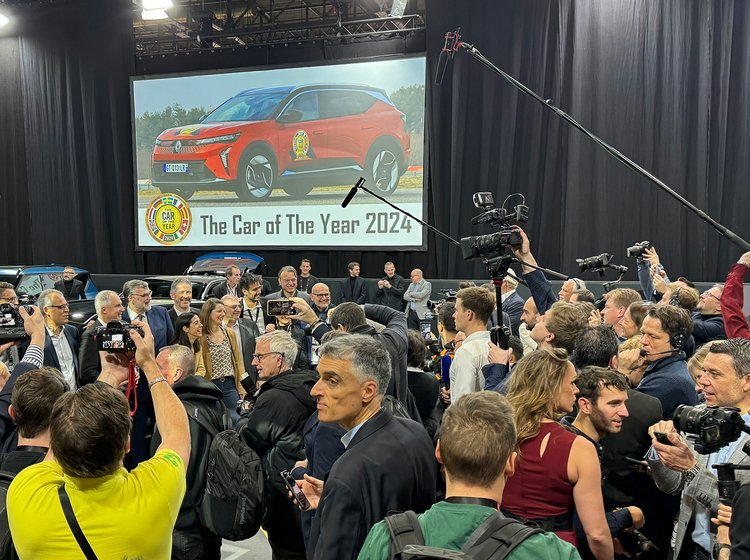 Menneskemængde med Renault-billede i baggrunden.