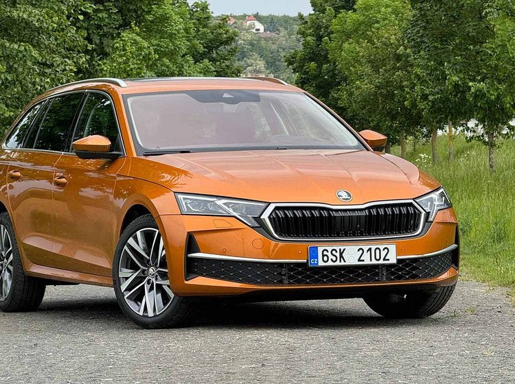 En orange Skoda Octavia holder på en vej med træer i baggrunden