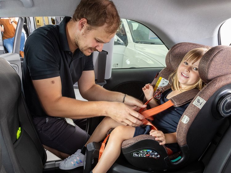 Mand spænder pige fast i autostol