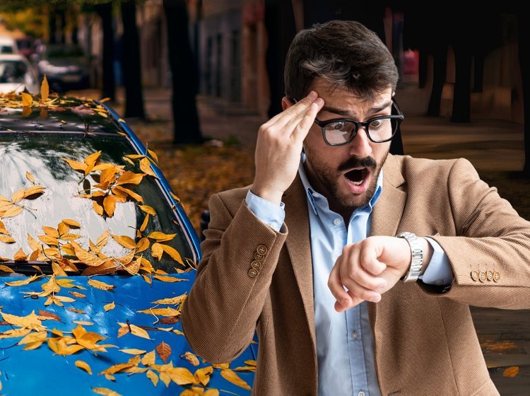 Mand ved parkeret bil ser forskrækket på sit ur