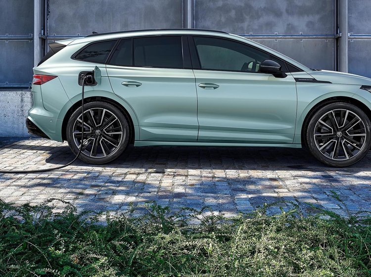 Skoda Enyaq holder og lader ved en Ionity-lader. Der er grønt i forgrunden. 