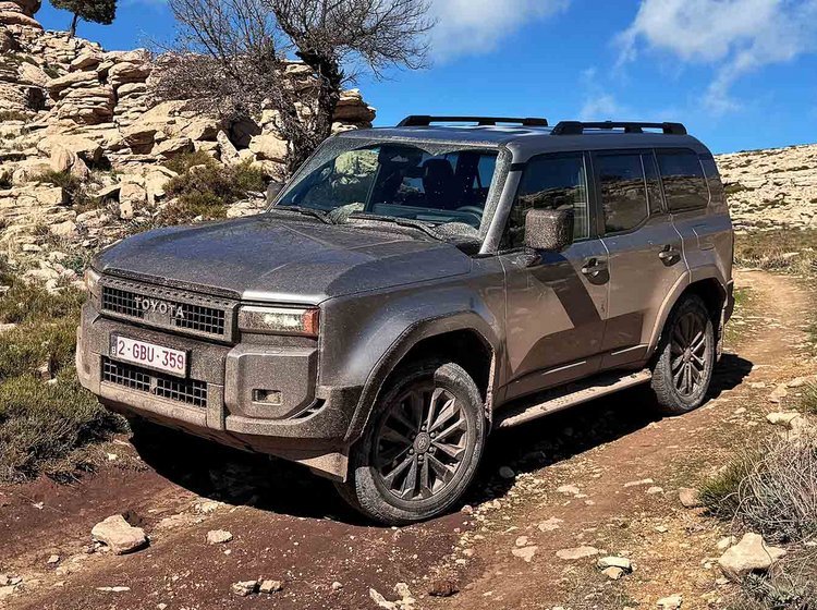 Snavset Toyota Land Cruiser på vej ned ad en bakke