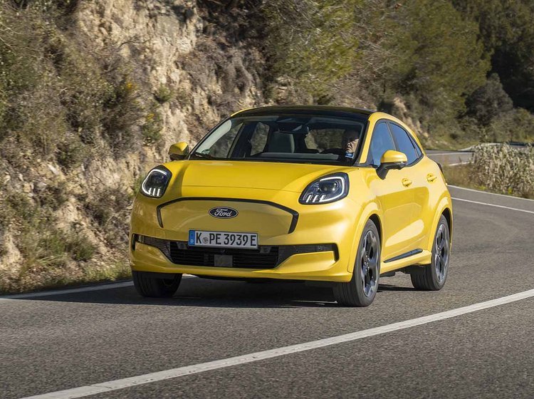 Gul Ford Puma set forfra kører i sving på bjergvej