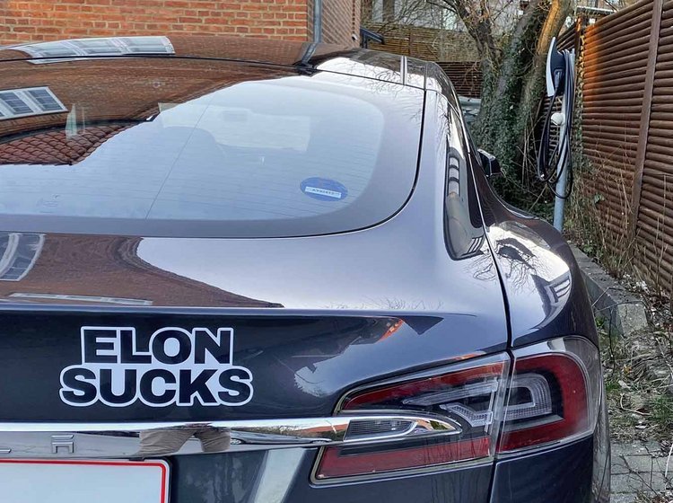 Tesla Model S med "Elon Sucks"-mærkat parkeret i indkørsel