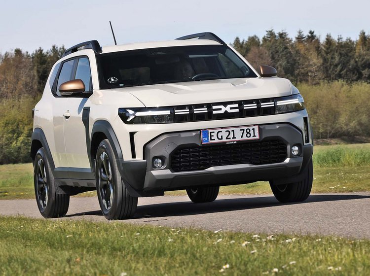 Dacia Duster set forfra, mens den kører på landevej med træer i baggrunden