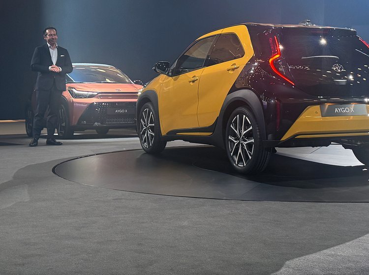 Gul Toyota Aygo X bagfra på scene.