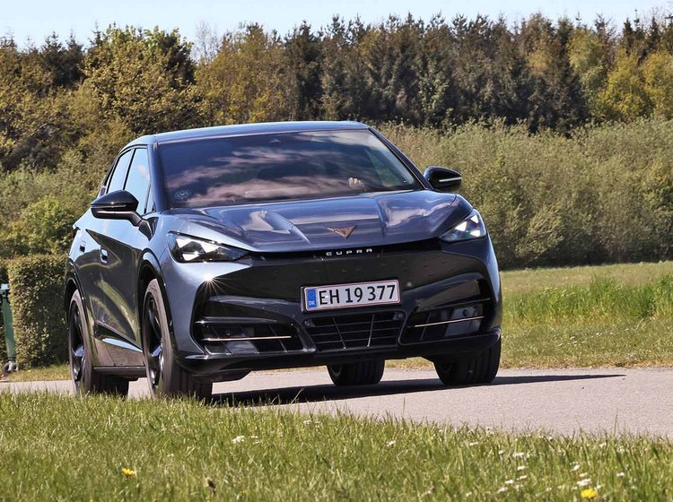 Cupra Tavascan set forfra, mens den kører på en vej med træer i baggrunden