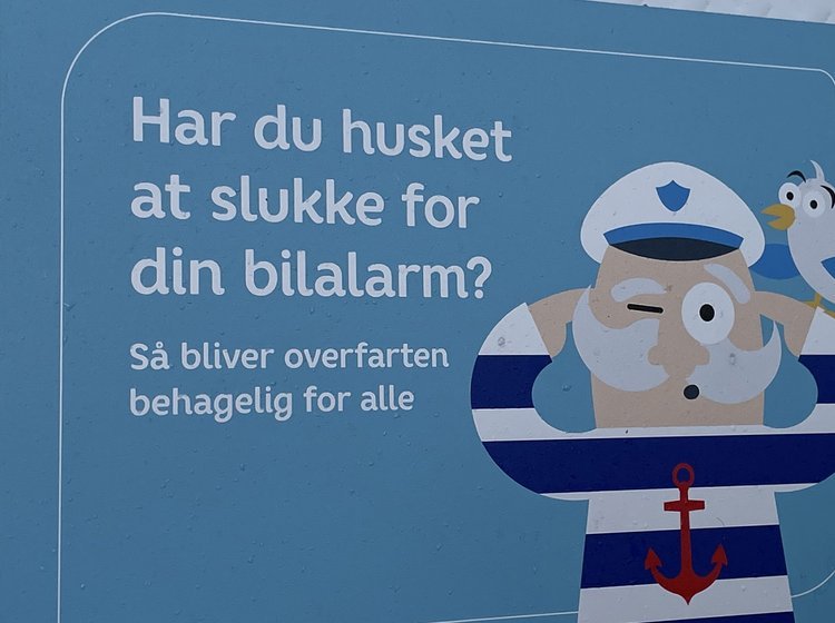 Skilt på færge med henstilling om at slå bilalarmen fra på overfarten
