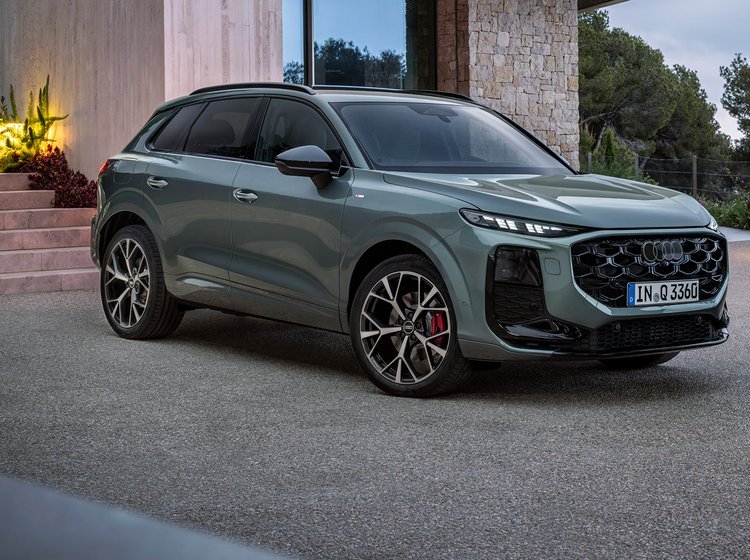 Audi Q3 skråt forfra foran villa i tusmørke.