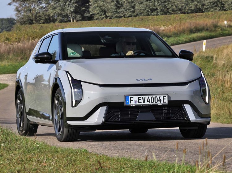 Kia EV4 set forfra, mens den kører på bugtet vej