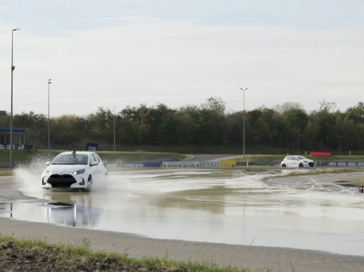 Hvid bil på glatbane på køreteknisk anlæg