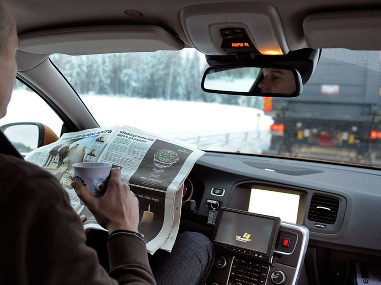 Uden hænder: Føreren i Volvo-testbilen kan læse avis, mens en lastbil "trækker" personbilen efter sig.