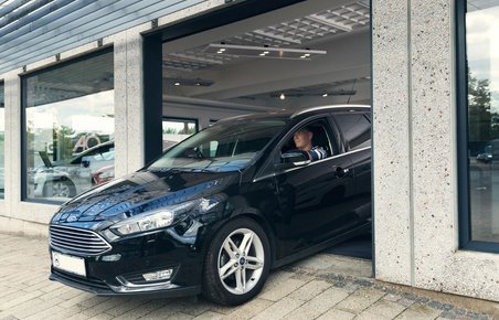 Bil kører ud fra bilforhandler