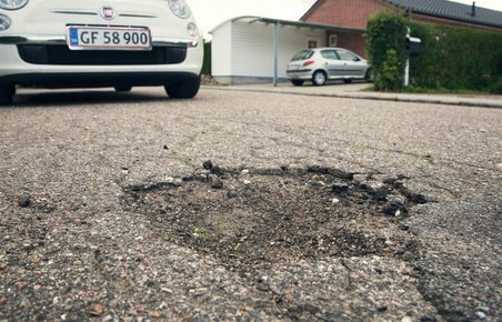 Hul i asfalt og bil