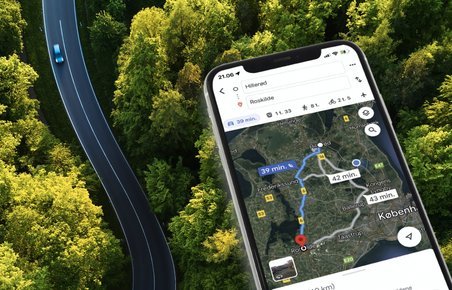 Bil på landevej og mobiltelefon med app