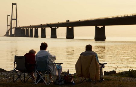 Mennesker ser på solnedgang ved Storebæltsbroen