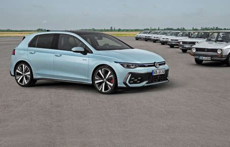 VW Golf skråt forfra med de ældre generationer i baggrunden.