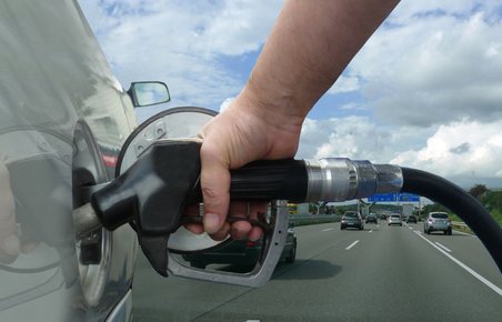 Bil bliver tanket med motorvej i baggrunden