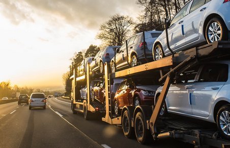 Autotransporter kører på motorvej med et helt læs biler. 