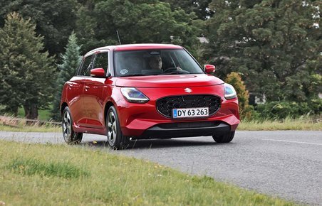 Rød Suzuki Swift kører på vej
