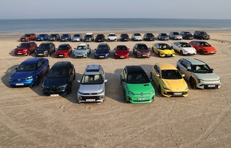 Mange biler på sandstrand.
