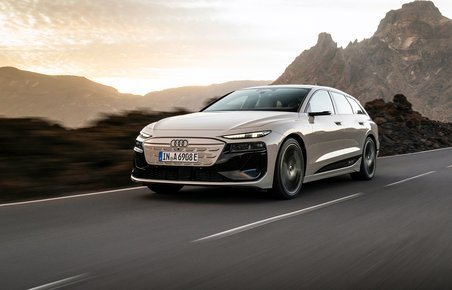 Audi A6 e-tron i fart på vej med klippeparti i baggrunden