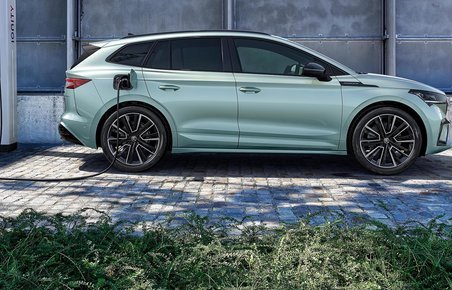 Skoda Enyaq holder og lader ved en Ionity-lader. Der er grønt i forgrunden. 