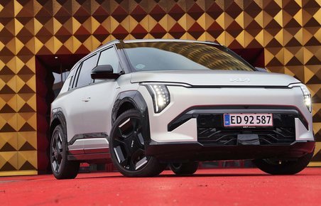 Kia EV3 holder på rød løber foran guldfarvet bygning
