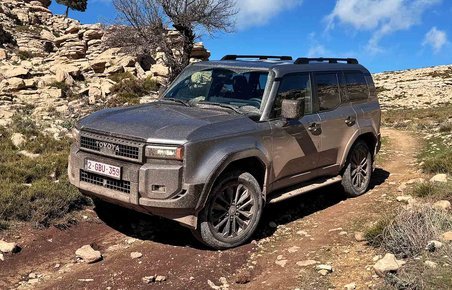 Snavset Toyota Land Cruiser på vej ned ad en bakke