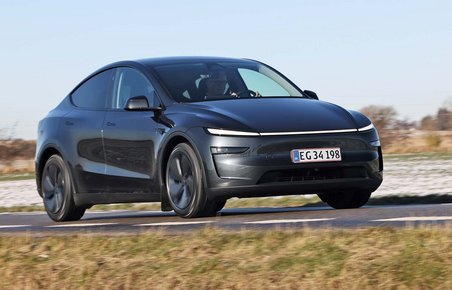 Tesla Model Y kører på landevej med sne i baggrunden