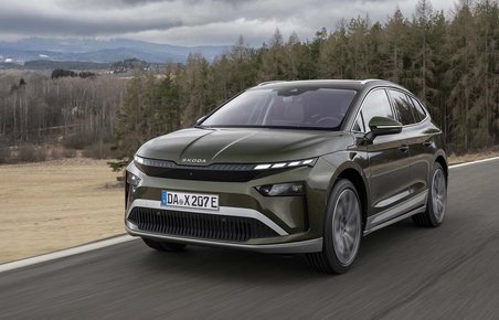 Skoda Enyaq set forfra, mens den kører på vej med træer i baggrunden