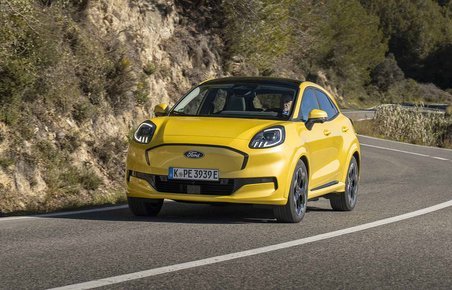 Gul Ford Puma set forfra kører i sving på bjergvej