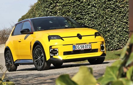 Gul Renault 5 set forfra med buske i forgrunden