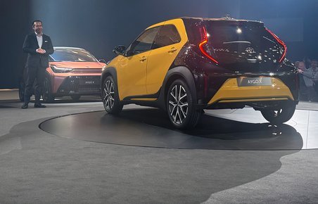 Gul Toyota Aygo X bagfra på scene.