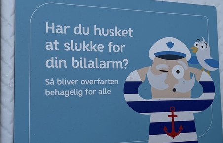 Skilt på færge med henstilling om at slå bilalarmen fra på overfarten