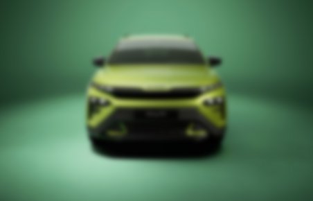 En sløret Skoda Enyaq fotograferet i et grønt studiemiljø. 