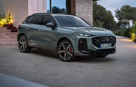Audi Q3 skråt forfra foran villa i tusmørke.