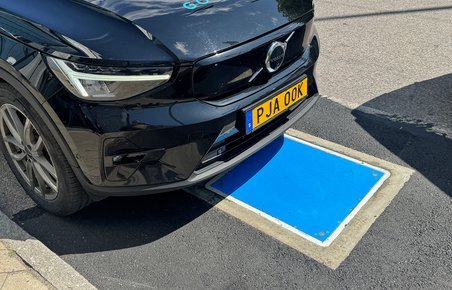 Snuden af Volvo over en blå plade i asfalten.