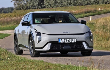 Kia EV4 set forfra, mens den kører på bugtet vej