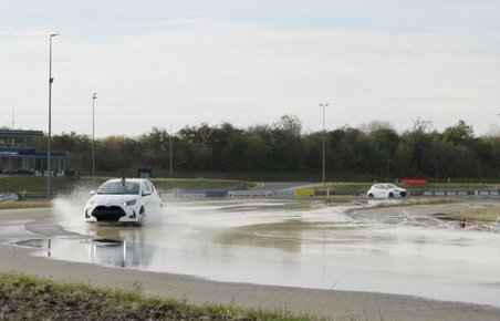 Hvid bil på glatbane på køreteknisk anlæg