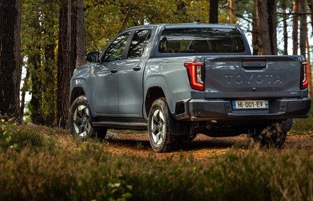 Toyota Hilux bagfra i skov.